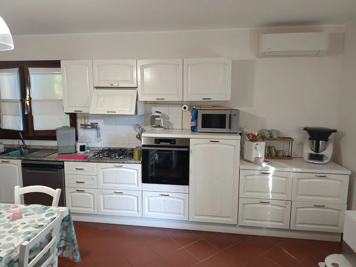 Cucina classica bianca con ante bugnate e forno in colonna